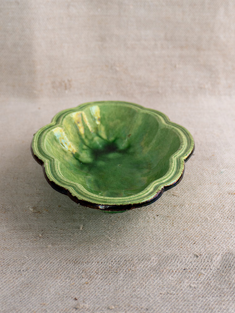 Antique French green glazed oval coupelle, lobed design, late 19th century, glossy finish on textured beige fabric.