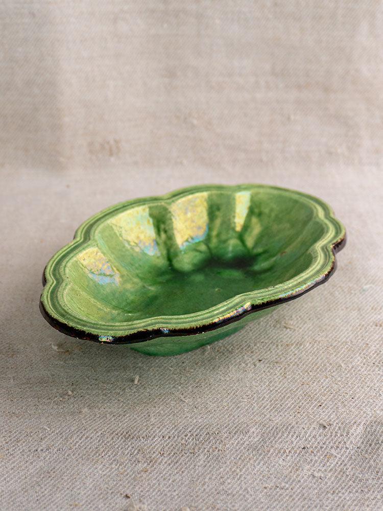 Antique French green glazed lobed oval coupelle with glossy finish, late 19th century, on beige fabric.