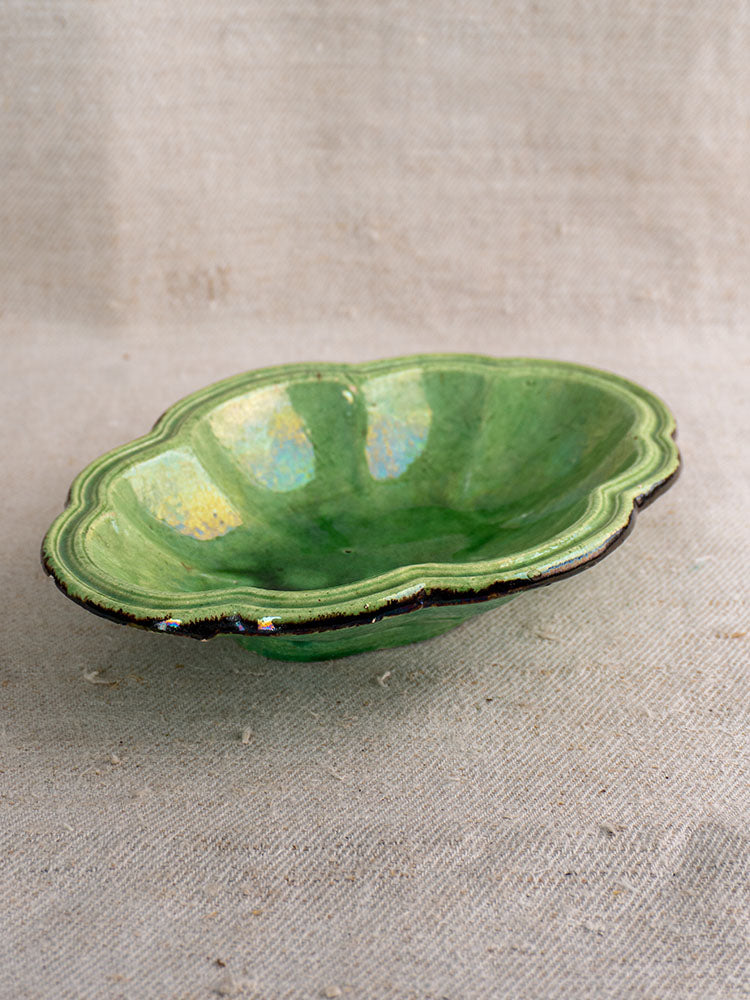 Antique French green glazed lobed oval coupelle, likely Dieulefit, late 19th century, on beige textured fabric.