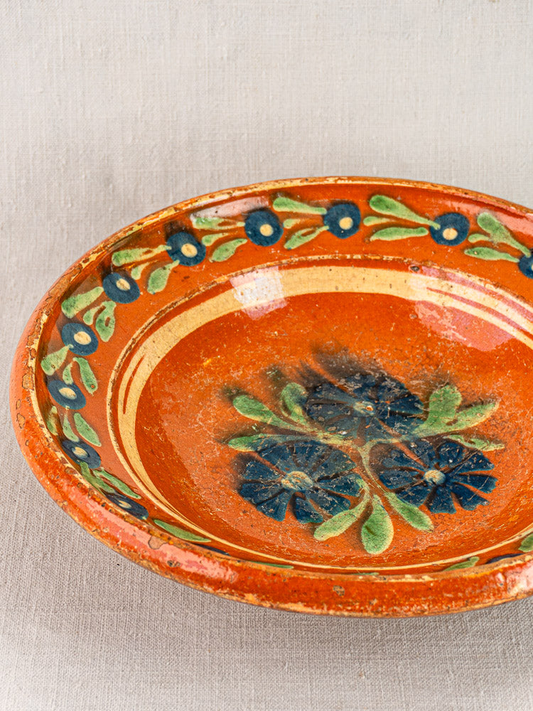 Antique French Alsatian Soufflenheim slipware plate with green and blue floral center and blue flower border.