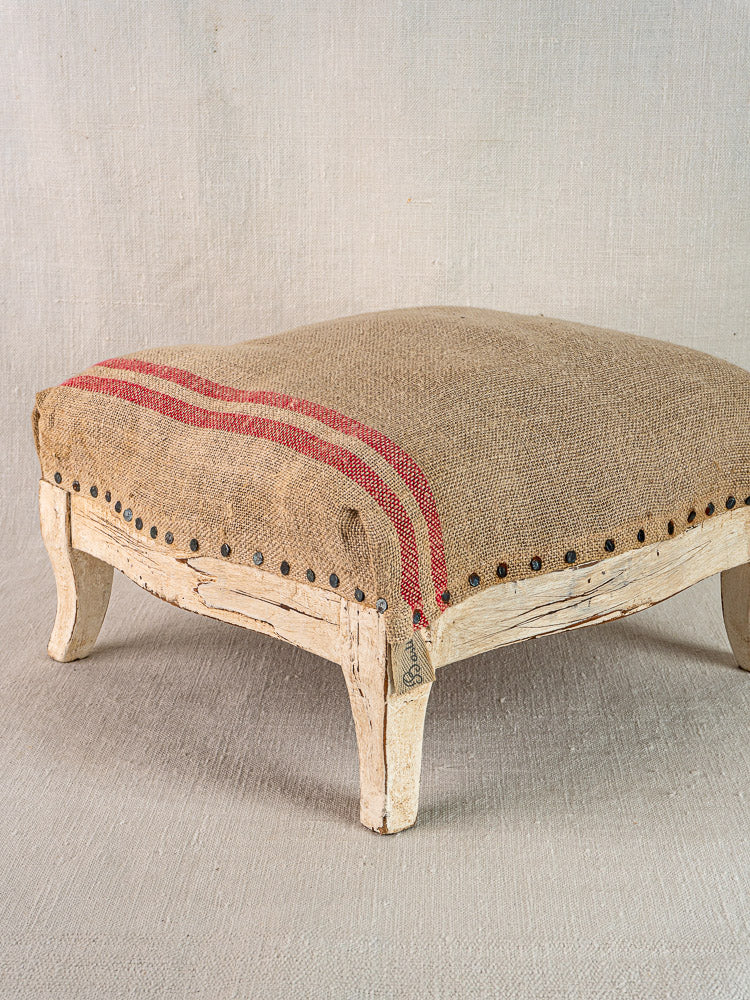 Antique French footstool with painted Louis XV frame, hemp torchon seat, red stripes, nailhead trim.