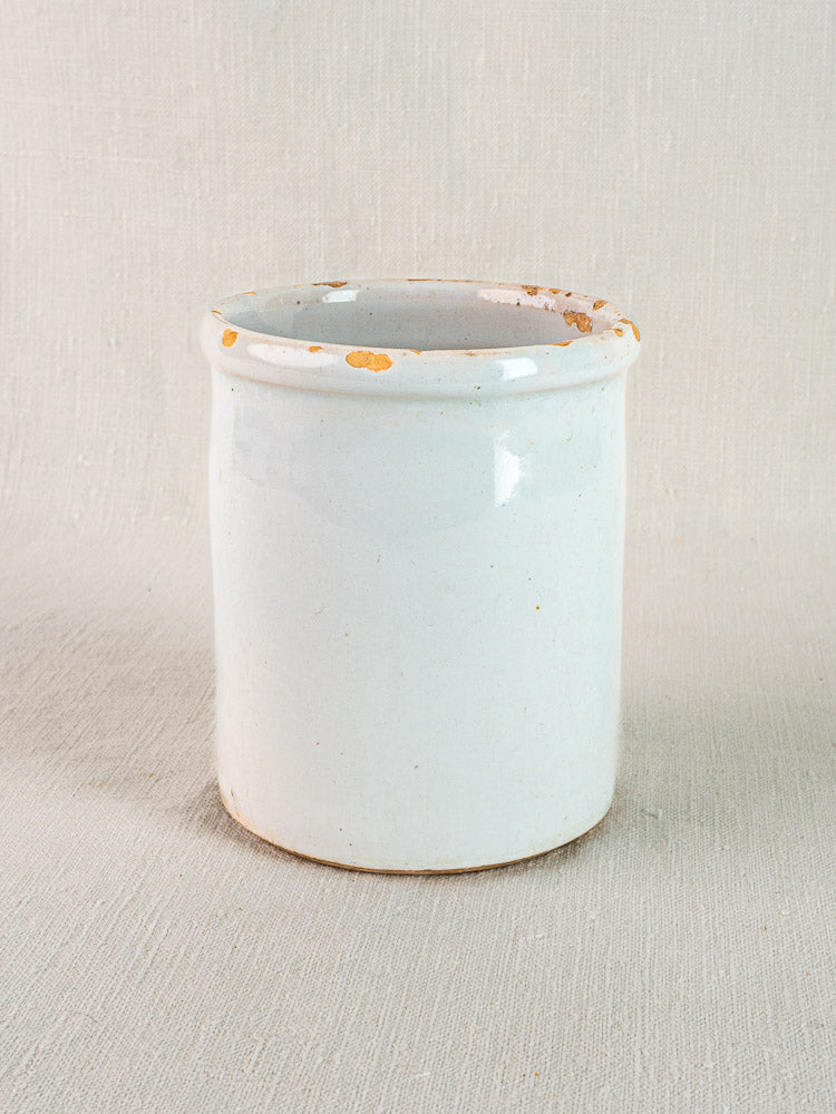Antique French white glazed earthenware Pot à Rillettes with orange-brown spots on textured surface.