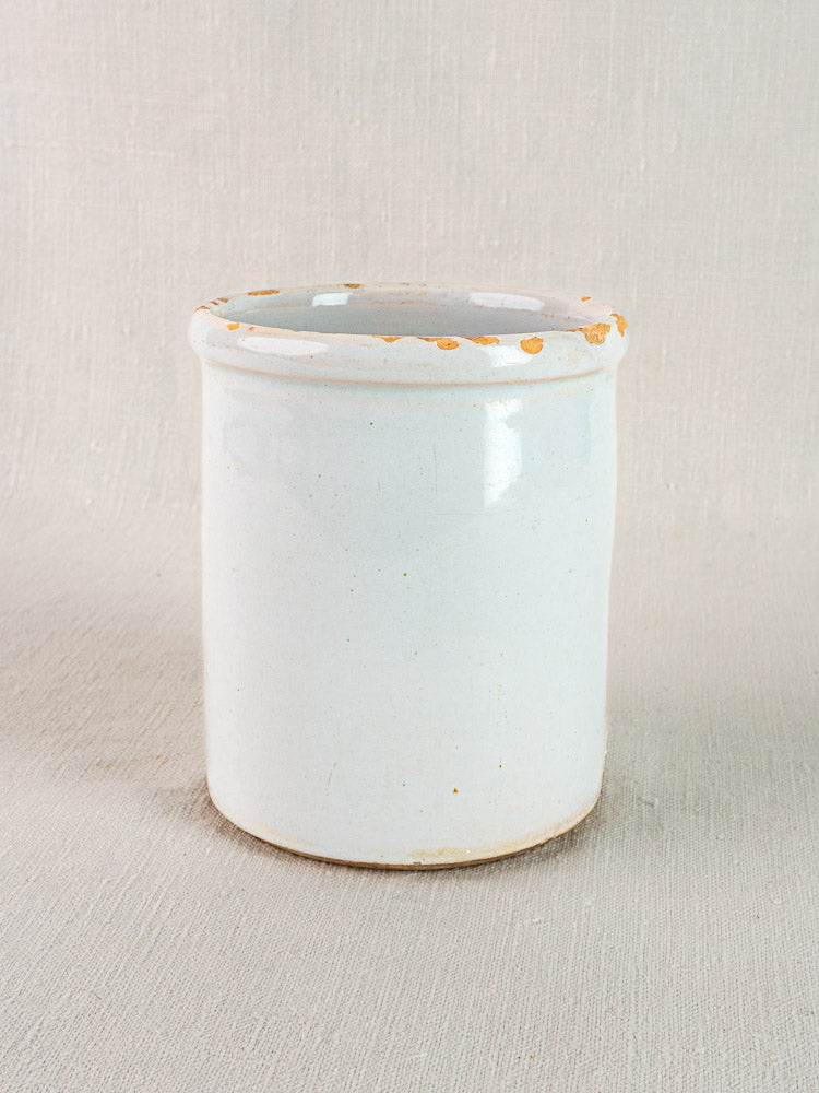 Antique French white glazed earthenware Pot à Rillettes with flared rim and light edge wear on neutral fabric.