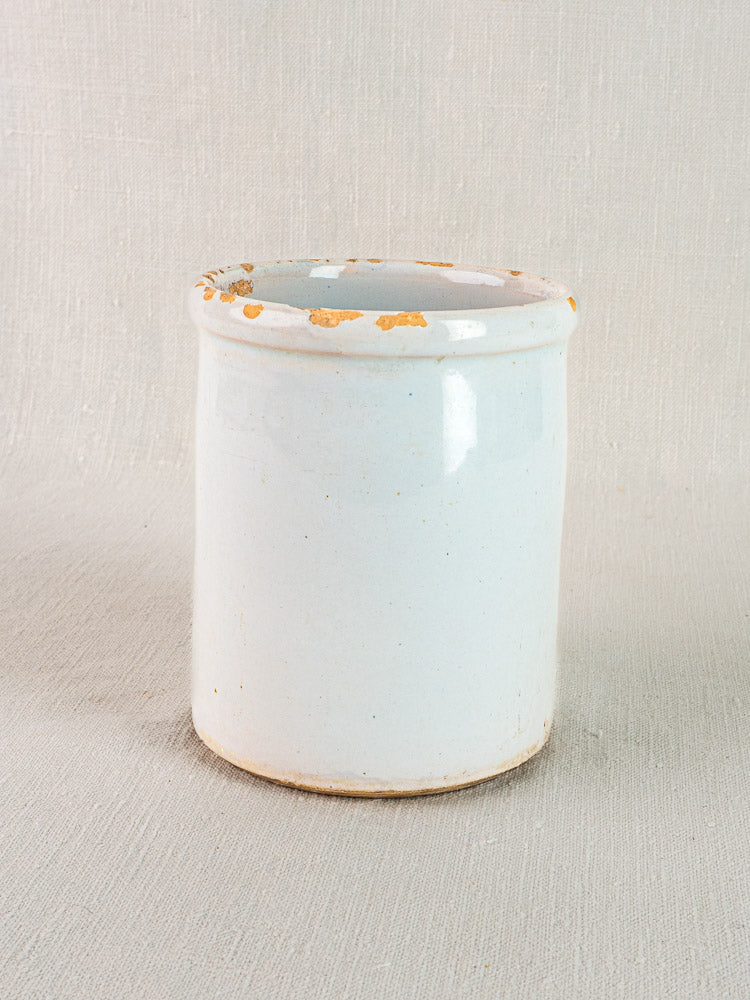 Antique French white glazed earthenware Pot à Rillettes with worn rim, on neutral fabric background.