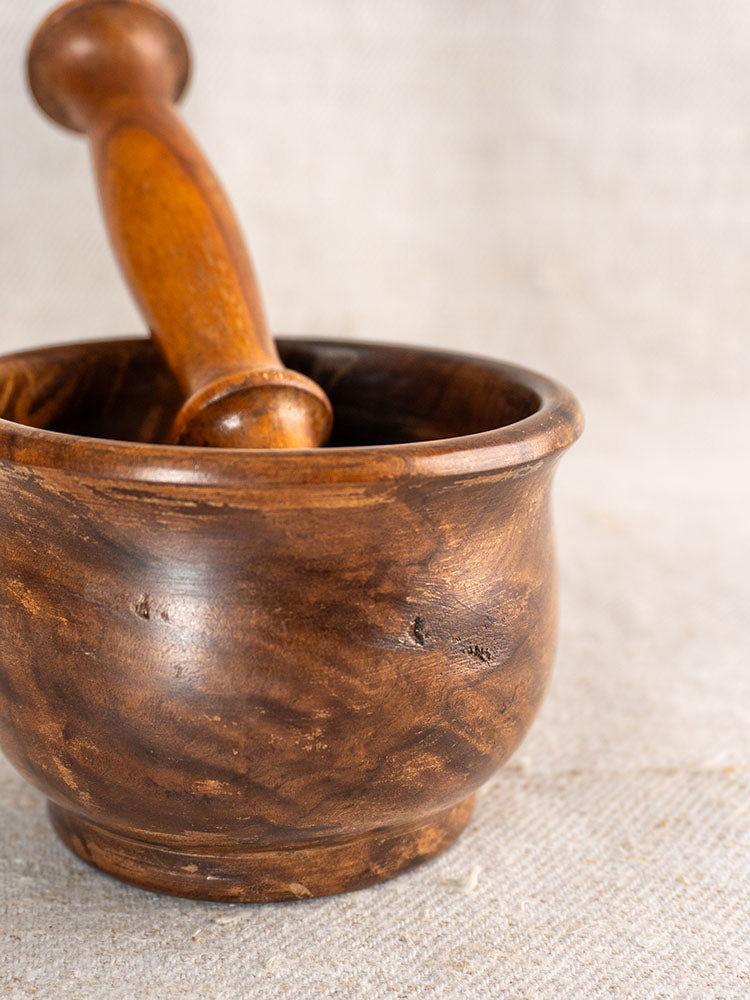 Antique French wooden mortar and pestle, 19th century, hand turned, on light textured fabric.
