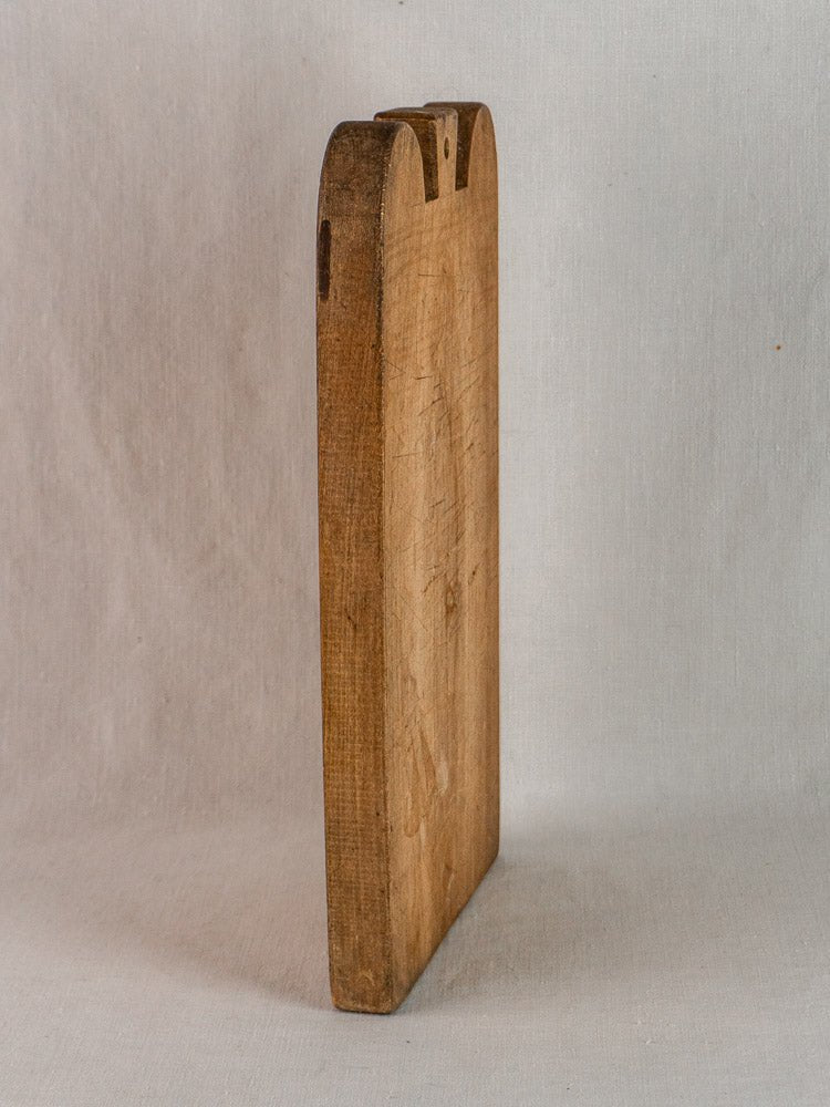 Early 20th-century French hardwood cutting board with double-lobed top and visible aged wood grain.