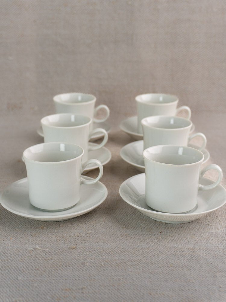 Set of six vintage Hutschenreuther porcelain espresso cups and saucers arranged on textured fabric.
