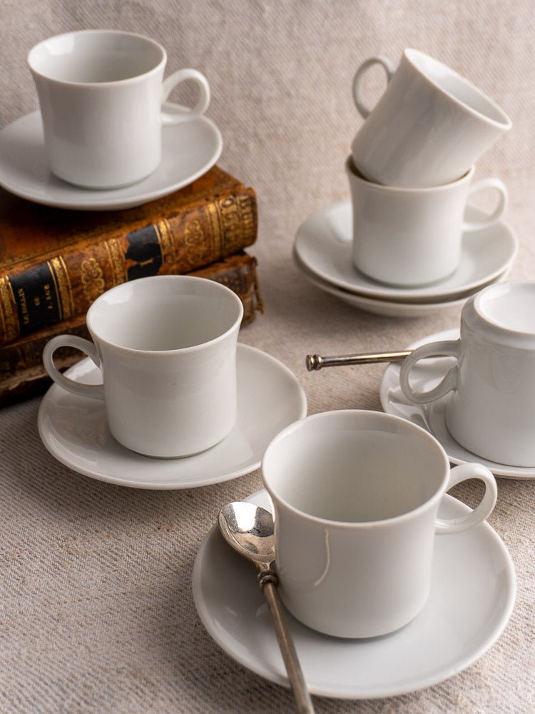 Vintage Hutschenreuther German porcelain espresso cups and saucers with two antique books and silver spoons.