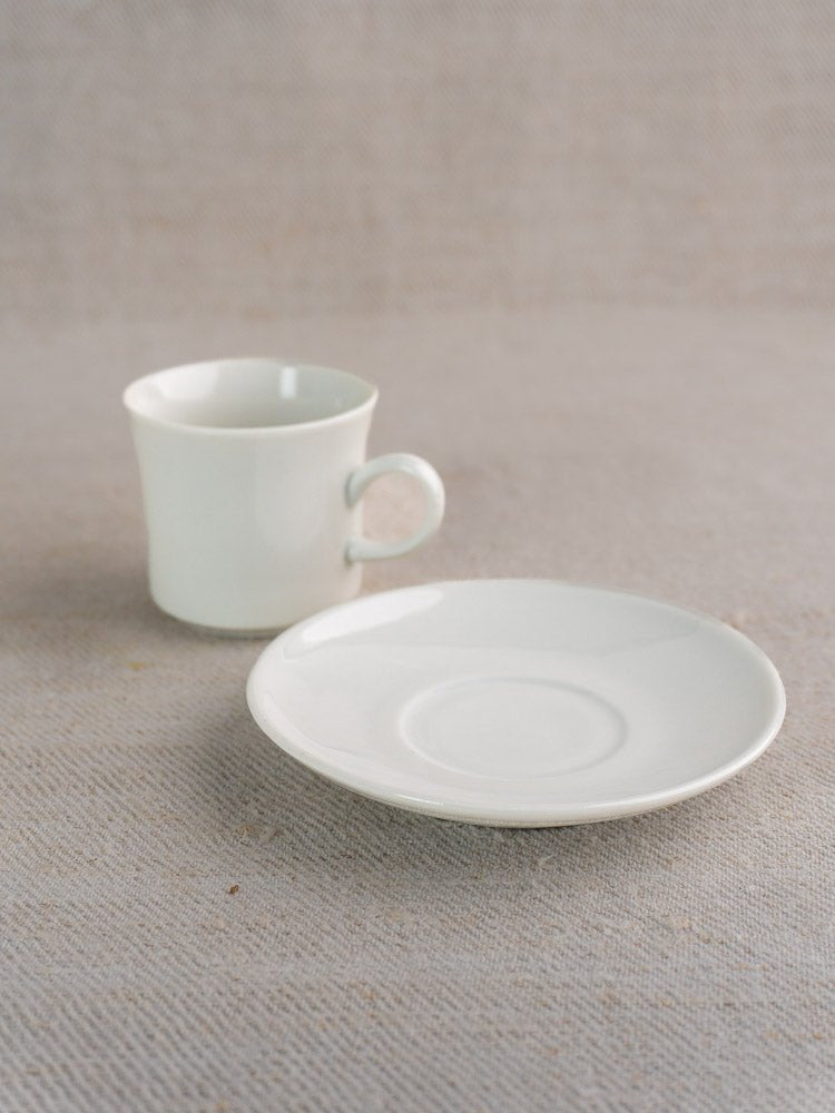 Vintage Hutschenreuther porcelain espresso cup and saucer arranged on a light textured surface.