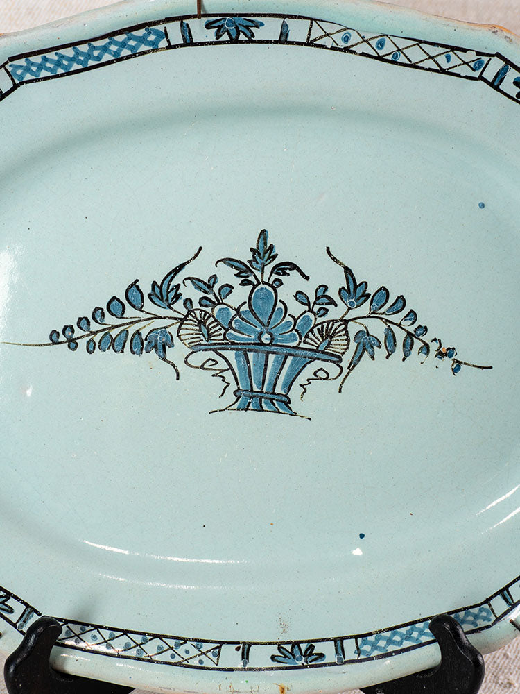 Antique French faience platter, Cul Noir, light blue glaze, stylized floral vase motif, blue and black patterned rim.