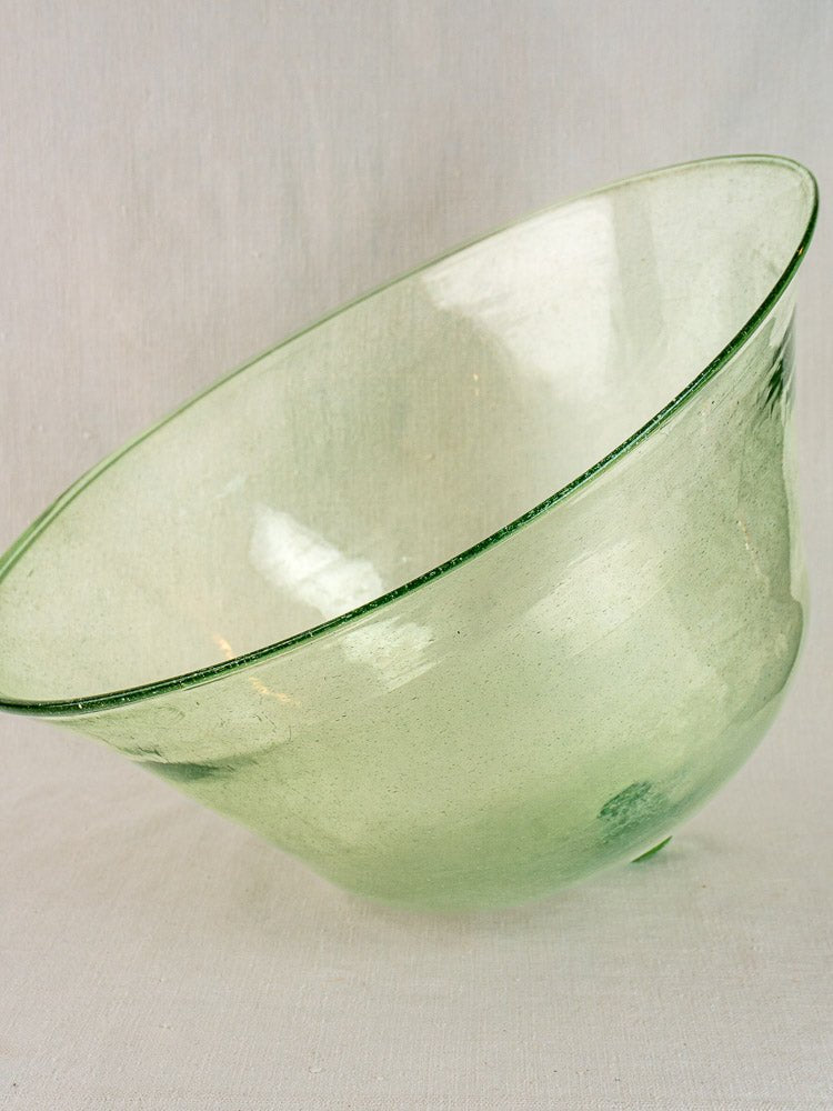 19th-century hand-blown French glass garden cloche in pale green, translucent and slightly asymmetrical, on a neutral background.