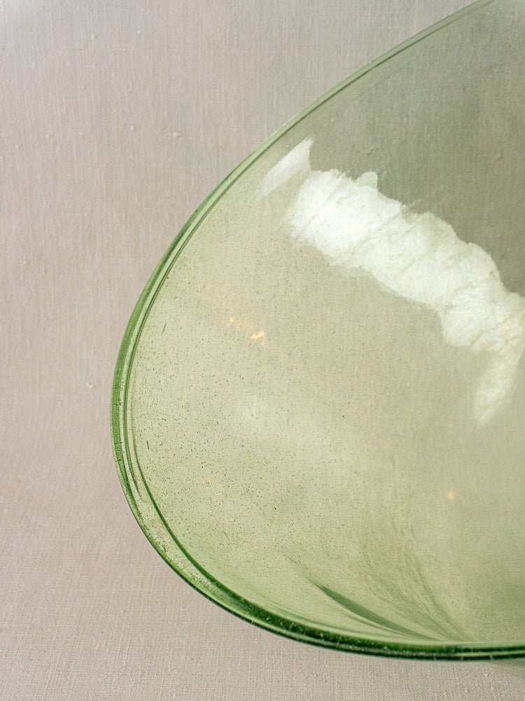 Antique French hand-blown pale green glass garden cloche, 19th century, subtle texture, neutral beige backdrop.