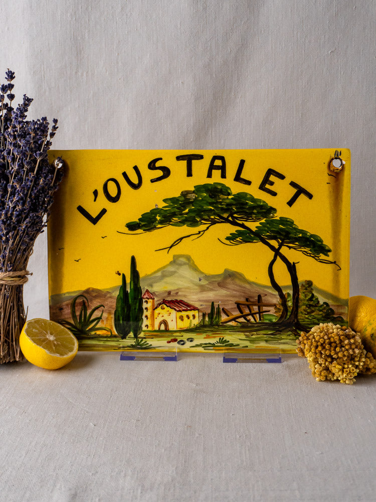 L’Oustalet French faience house plaque, hand-painted landscape and name on yellow ceramic, with dried lavender, flowers, lemons.