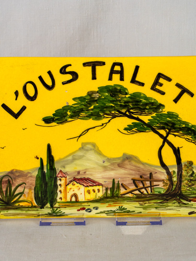 L’Oustalet French faience plaque with hand-painted Provençal landscape, house, trees, hills, and rustic fence.