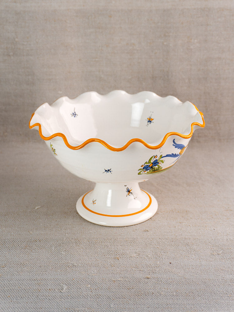 Pair of hand-painted French faience Moustiers-style compotes with orange-edged scalloped rims and floral motifs.