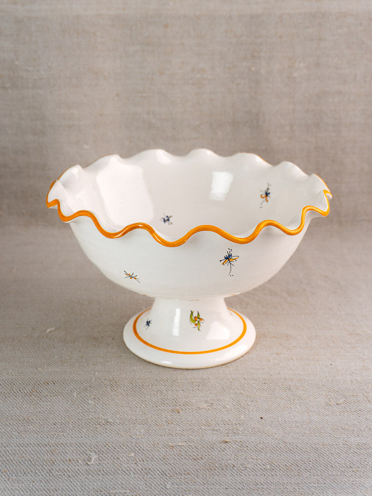 Pair of vintage French Moustiers-style faience compotes with wavy orange-rimmed edges and insect motifs, on neutral fabric.