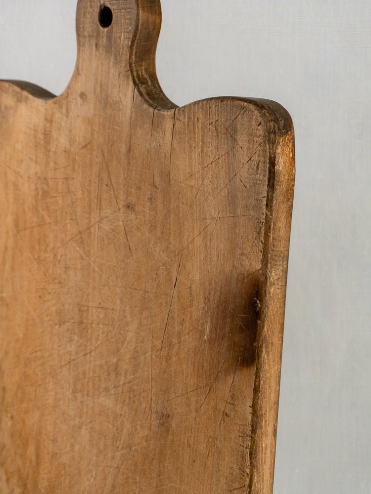 Large antique French hardwood chopping board, 19th century, scratched with a burn mark on light background.