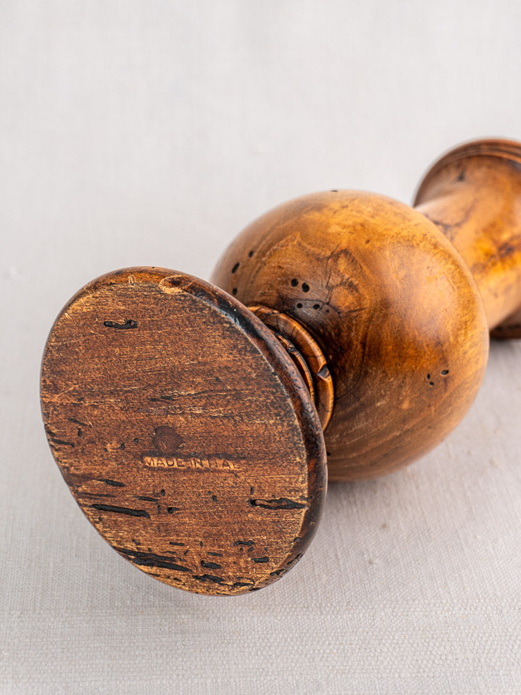 Antique Italian Stefano Ugolini pepper mill and salt set with wormwood, round base, dark accents on light fabric.