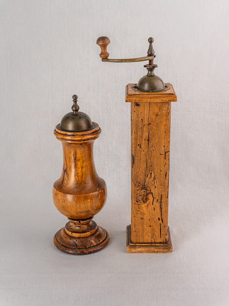 Antique Stefano Ugolini Firenze Italian pepper mill and salt grinder set in wormwood on a neutral background.
