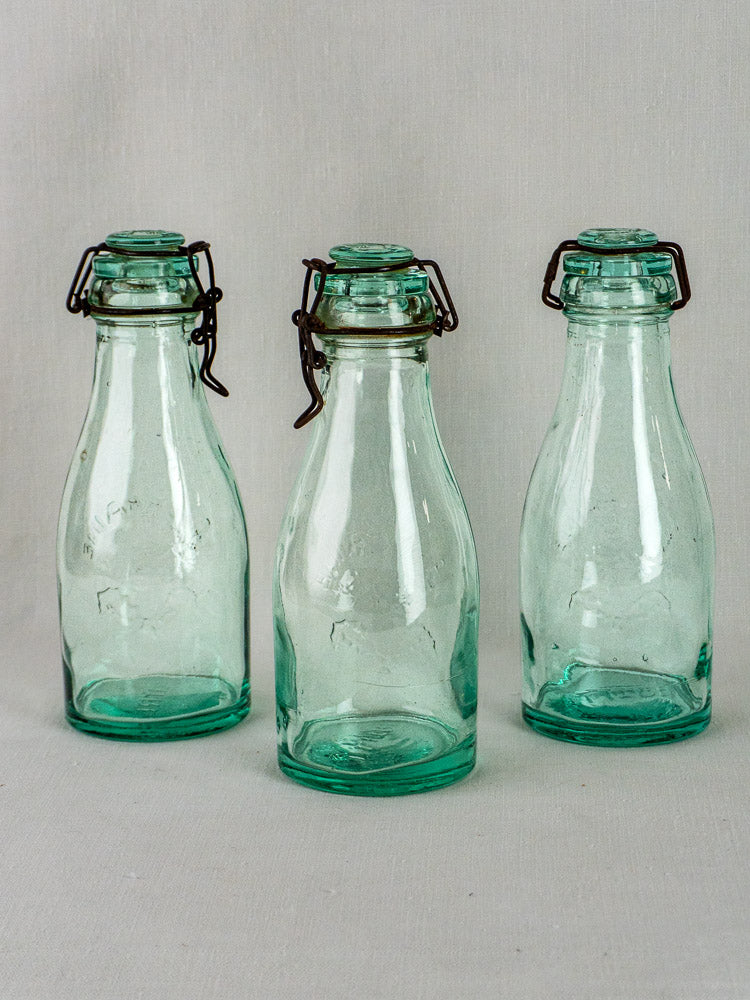 Set of three vintage La Lorraine French aqua glass preserving bottles with wire swing-top closures.