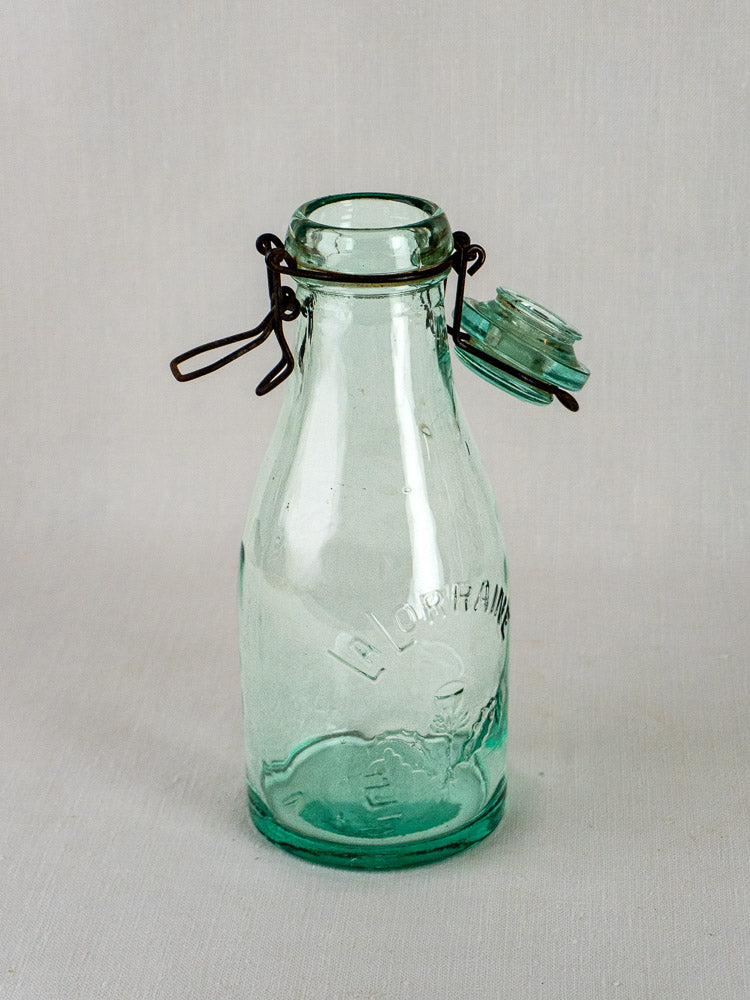 Set of three antique French aqua glass La Lorraine preserving bottles with embossed marks and metal swing tops.