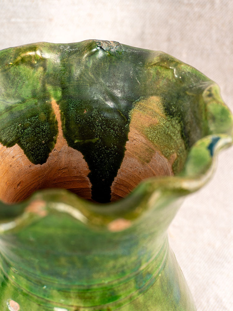 19th century French green glazed terracotta vase with scalloped rim, glossy finish, and rustic textured details.