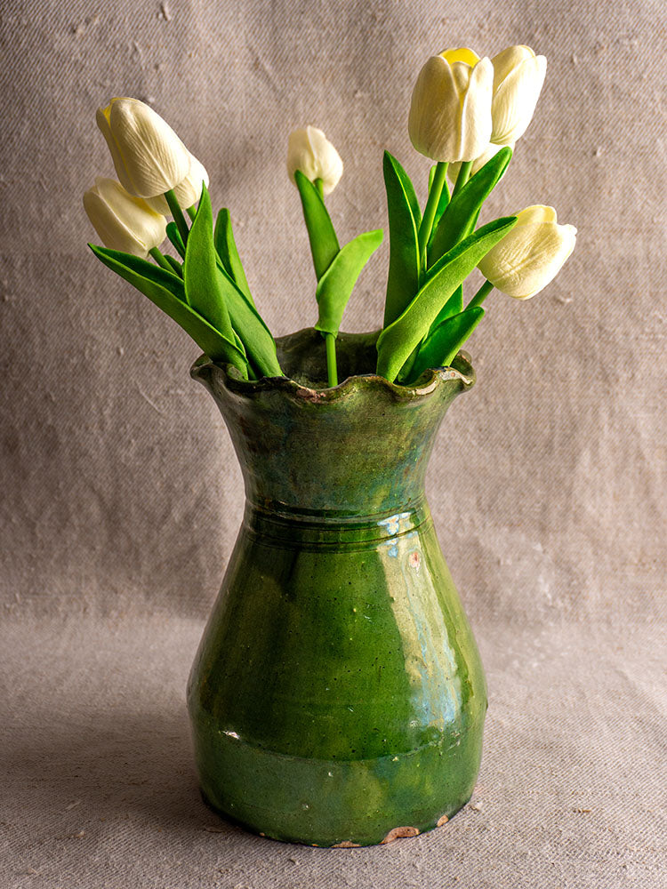 19th century French green glazed terracotta vase with scalloped rim, arranged with white tulips and green leaves.