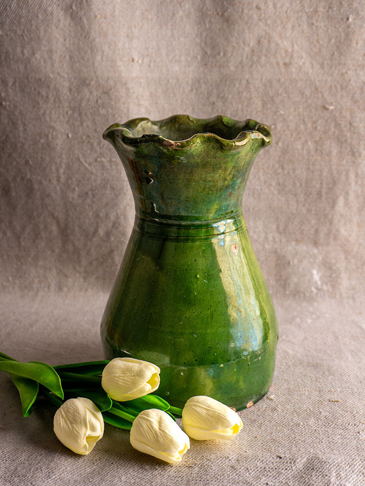 19th century French green glazed terracotta vase with scalloped rim, displayed on beige textured fabric near white tulips.