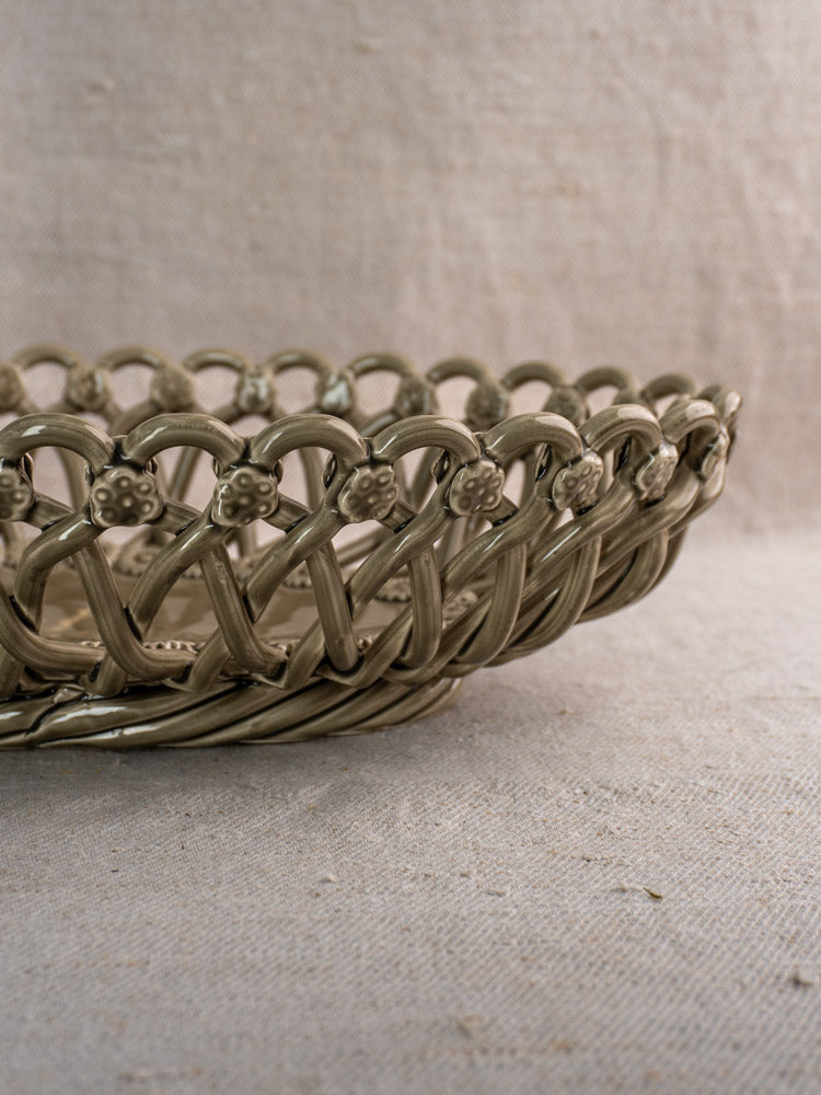 Large Vintage Pichon Uzès oval ceramic basket in Provence faience style with lattice and floral details on beige fabric background.