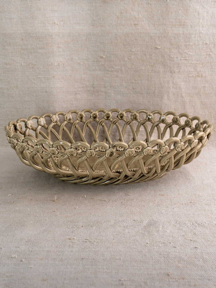 Large vintage Pichon Uzès basket in Provence faience ceramic, hand-woven oval form on beige textured fabric.