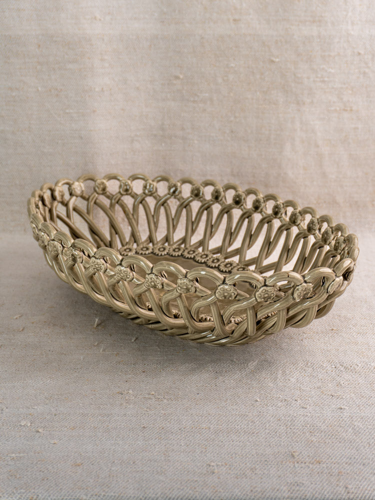 Large vintage Pichon Uzès oval ceramic basket in Provence faience style with intricate lattice, on textured beige fabric.