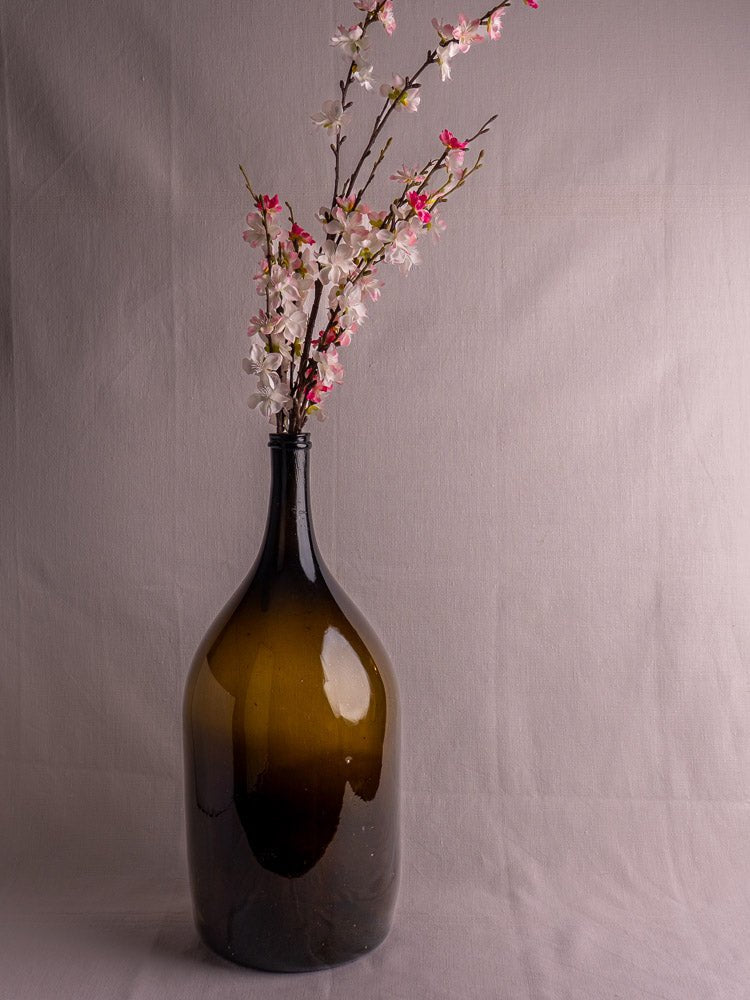 Antique French 19th-century olive green hand blown wine bottle with pink and white flowering branches.