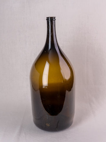 Antique French hand blown olive green glass wine bottle, 19th century, plain white background.