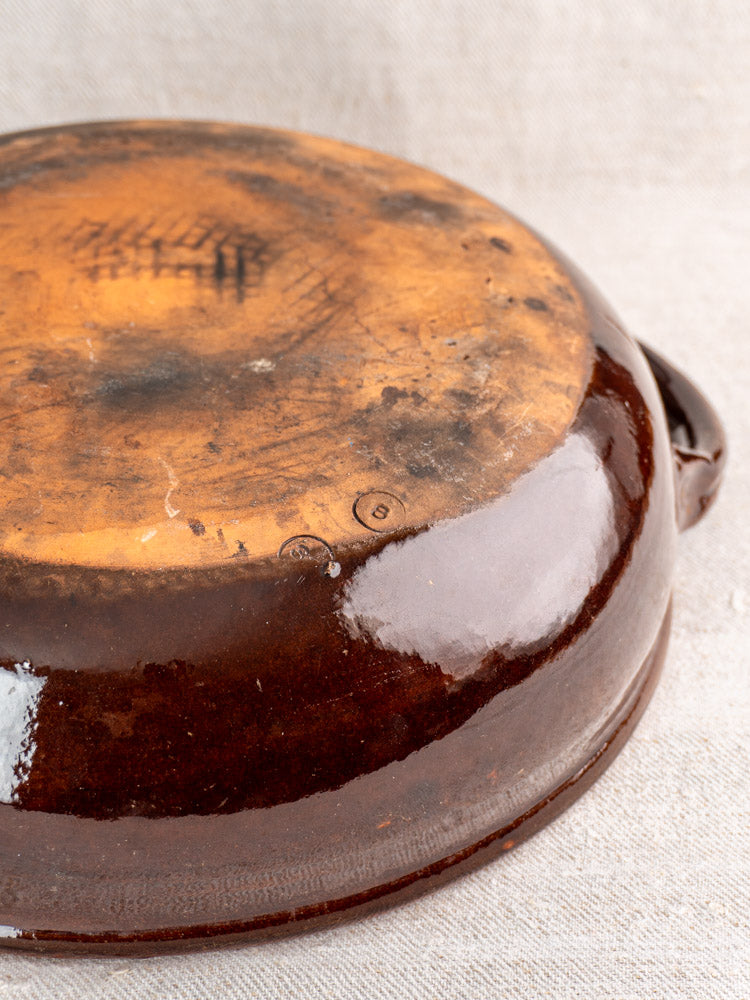 Antique French earthenware poêlon, brown glaze and caramel interior, mid 20th century, worn base with black marks.