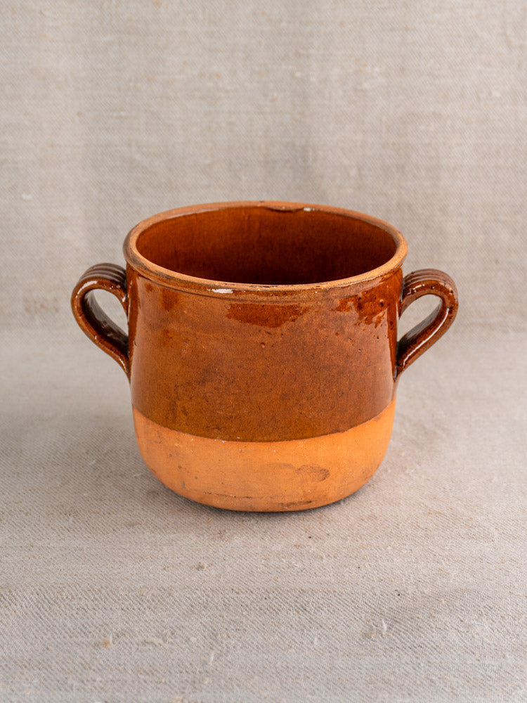 Antique French confit pot in brown glazed earthenware with two side handles and a matte lower section.