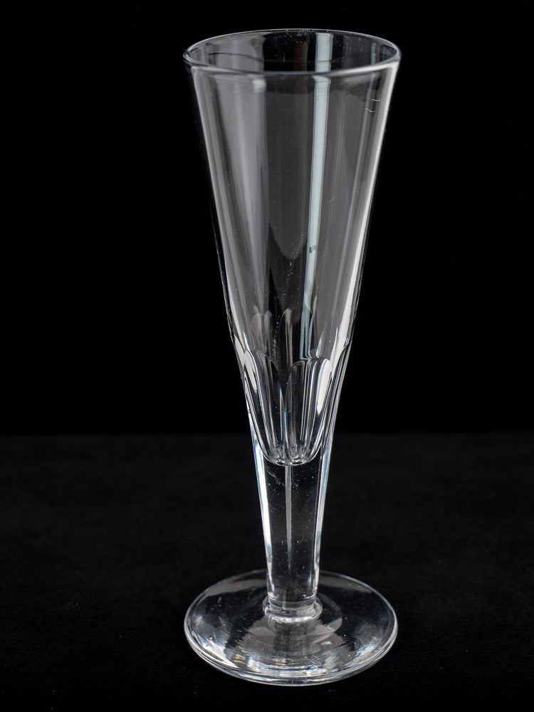 Set of six antique French cut crystal Champagne flutes from the early 19th century on a black background.