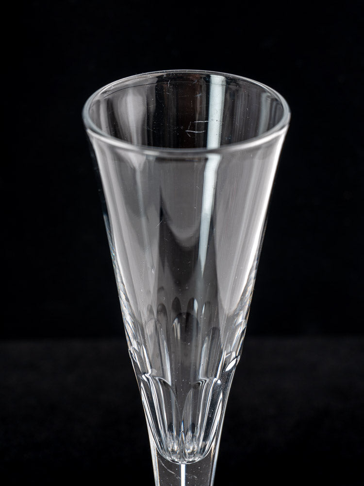 Set of six antique French cut crystal Champagne flutes with flared rims, faceted bowls, on a black background.
