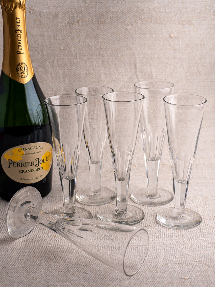 Set of six early 19th-century French cut crystal champagne flutes, one flute displayed on its side.