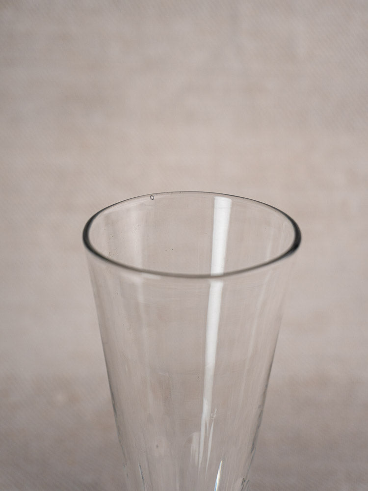 Antique French cut crystal Champagne flute with slightly flared rim, early 19th century, on a neutral background.