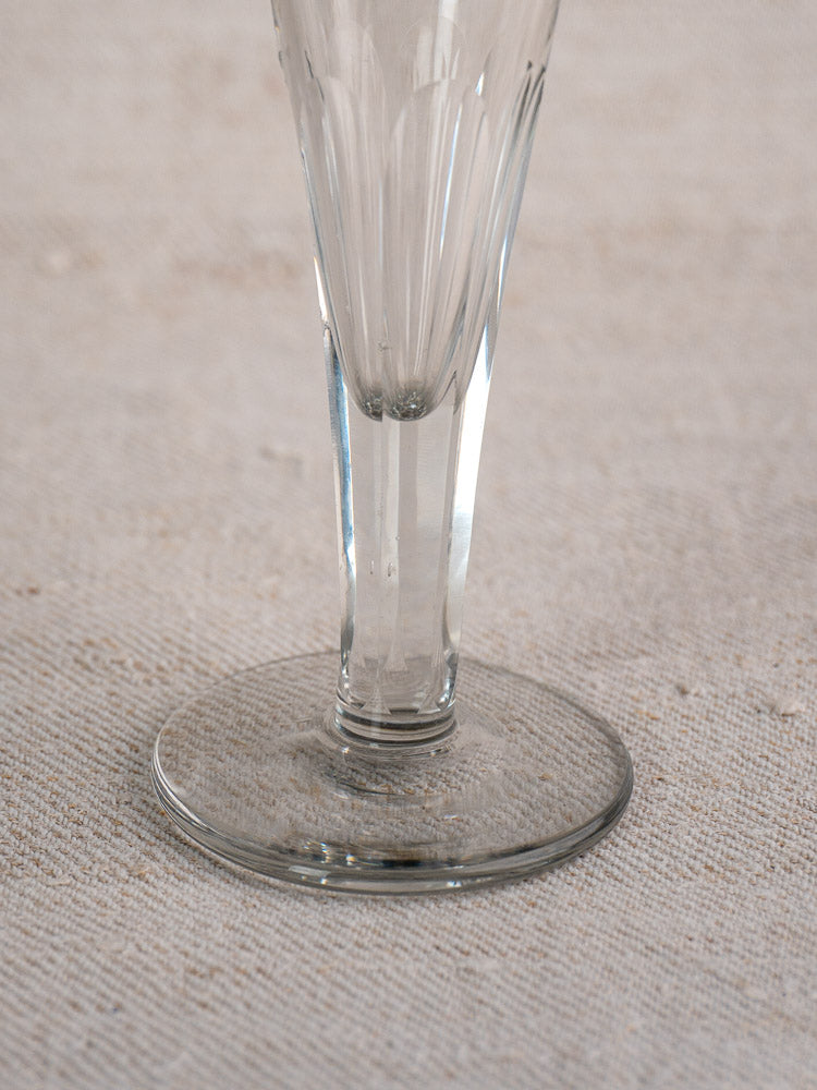 Antique French Champagne flute base and stem in cut crystal, early 19th century on beige textured fabric.