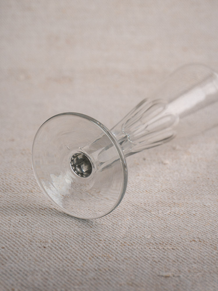 Antique French cut crystal Champagne flutes, early 19th century, shown base-up on textured light fabric.