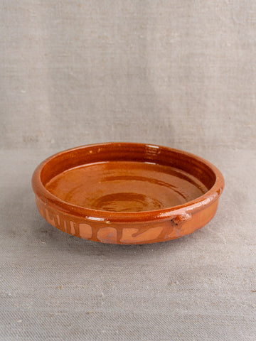 Antique French Tian glazed terracotta baking dish, early-mid 20th century, on neutral fabric background.
