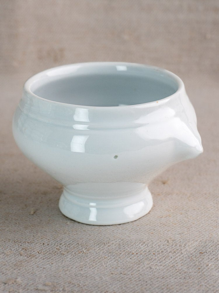 White ceramic lion head soup bowl with rounded body and flared base on beige surface.
