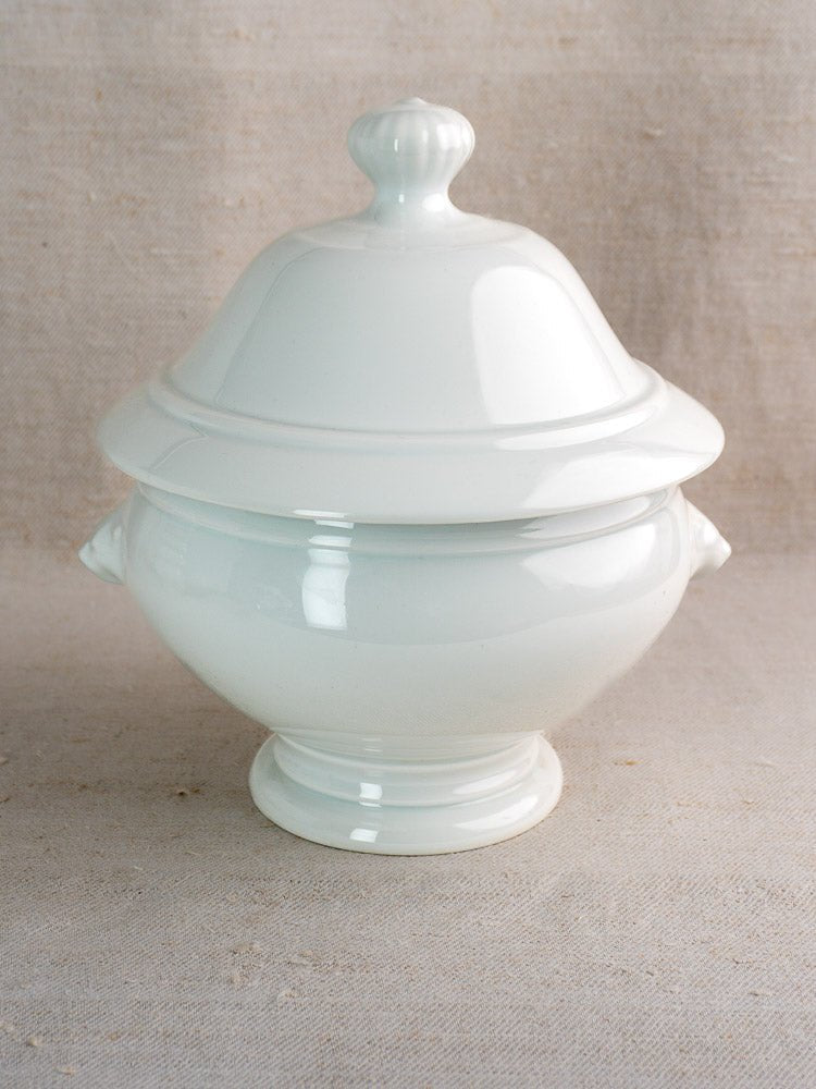 Vintage French CNP tureen with lid, side handles, and round knob on beige textured fabric.