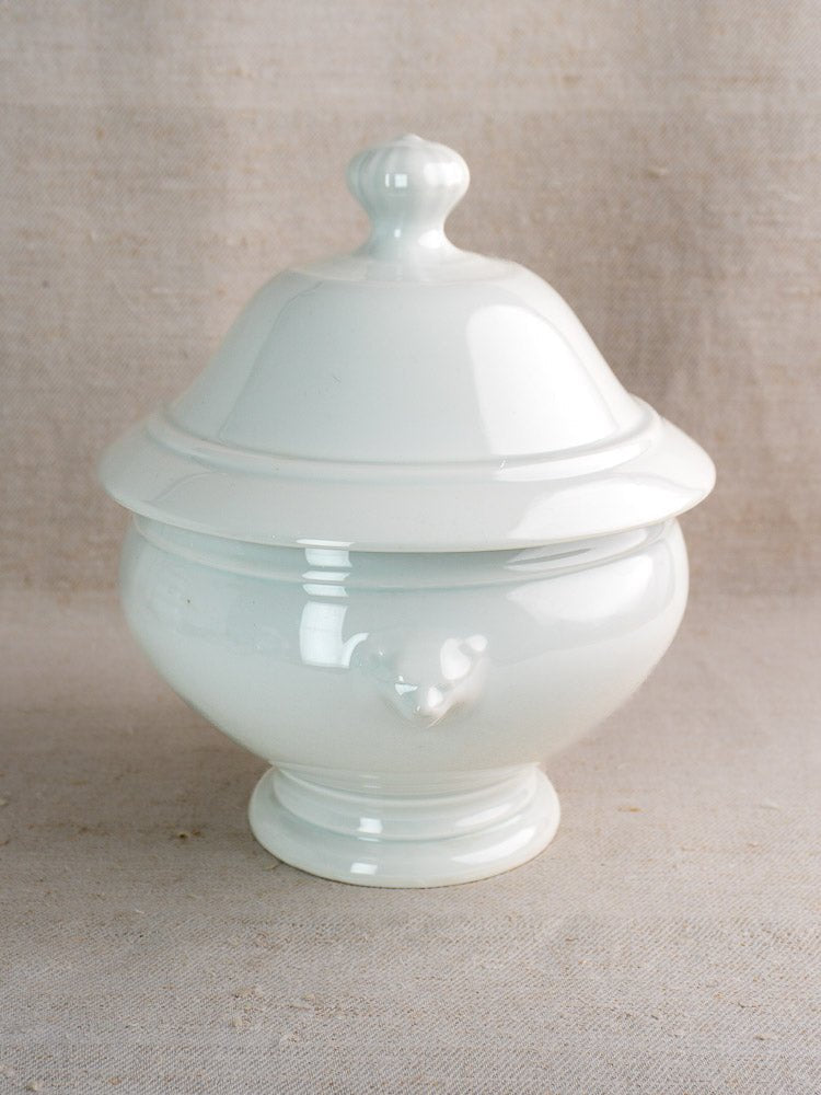 Vintage French CNP porcelain soup service with tureen and twelve lion head bowls on neutral fabric.