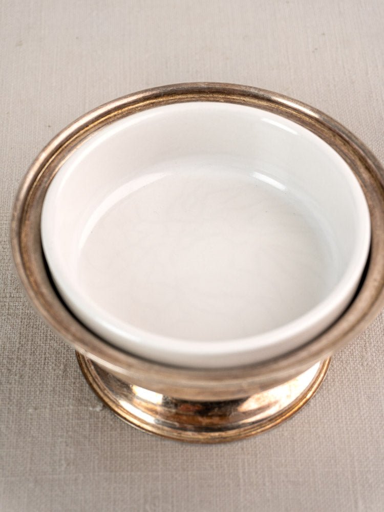 Set of six vintage Italian Sambonet coupes with white ceramic bowls in silver-plated holders on light linen.