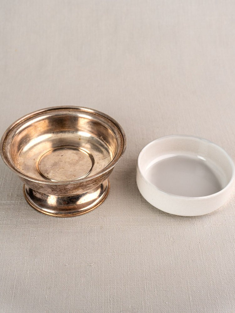 Six silver-plated vintage Italian Sambonet coupes displayed on a light beige textured surface with a small white ceramic dish nearby.