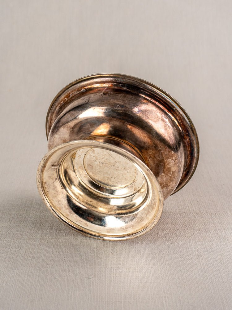 Set of six vintage Italian Sambonet silver plate coupes, one bowl resting on its side against light gray fabric.