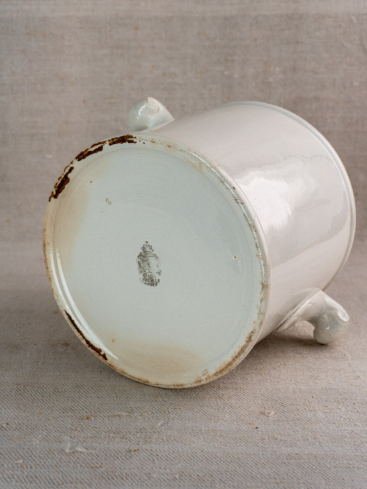 Antique French Lunéville white faience soup tureen base with brown edge, decorative handles, beige fabric backdrop.