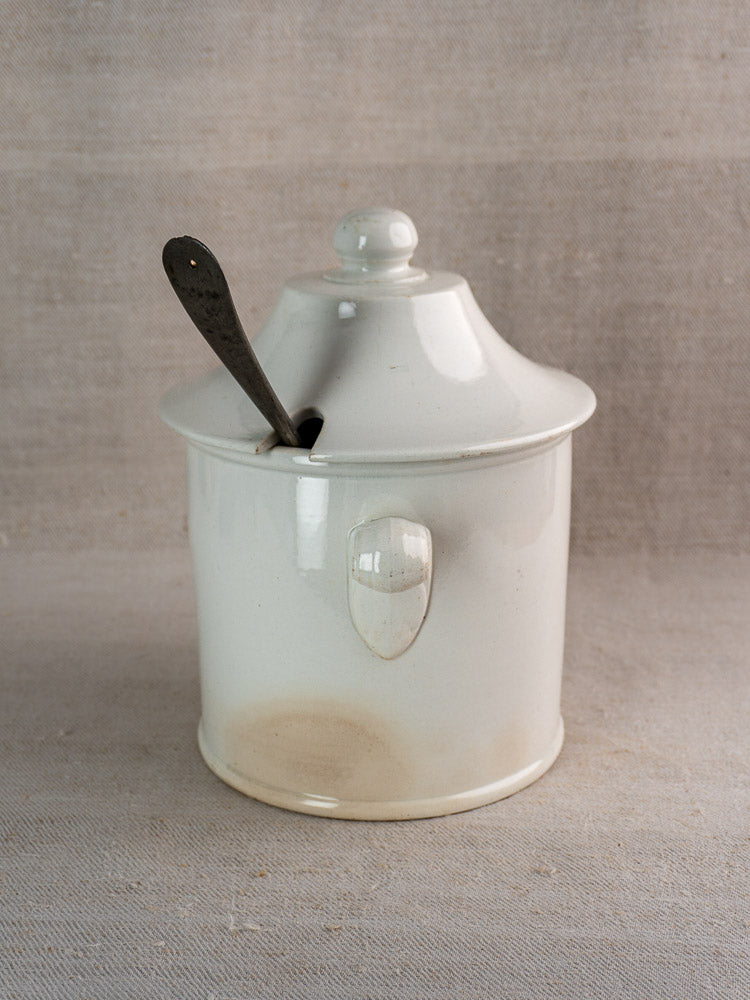 Antique French Lunéville white faience soup tureen with lid and front handle on neutral fabric.